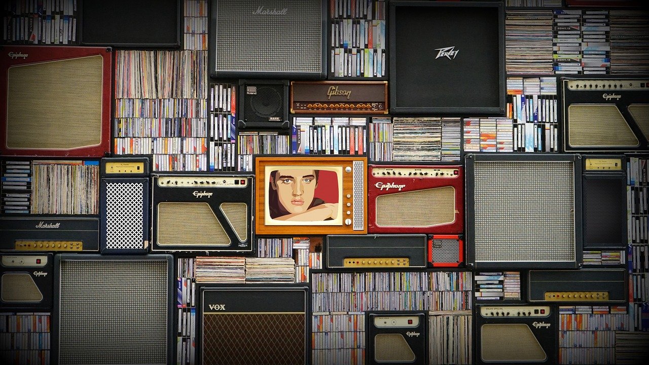 A tv with elvis presley on it, crammed in among many records