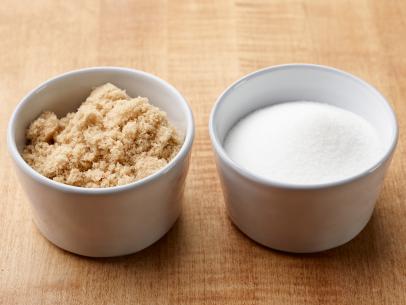 two white bowls, one with brown sugar in it, the other with white sugar