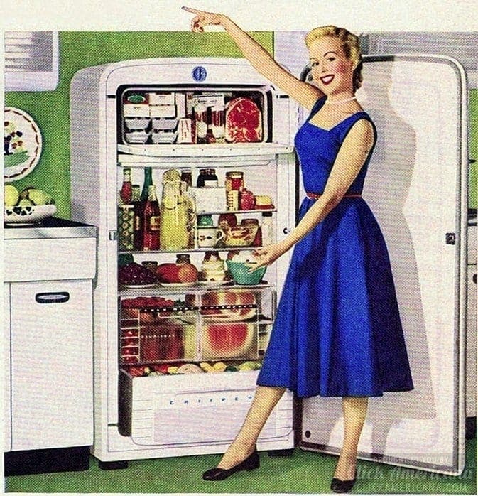 A 1950s advertisment of a woman in a blue swing dress standing in front of an open fridge filled with food