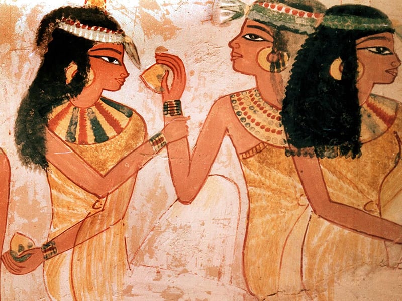 ancient Egyptian relief of two women, one presenting an item to another 