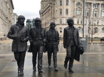 a color photo of a statue of the four musicians that make up the Beatles