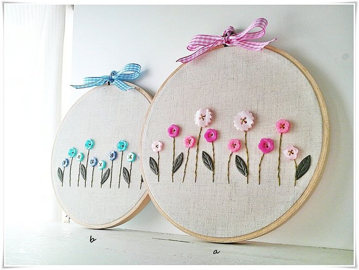 small color photo of two embroidery hoops one with blue flowers and another with pink