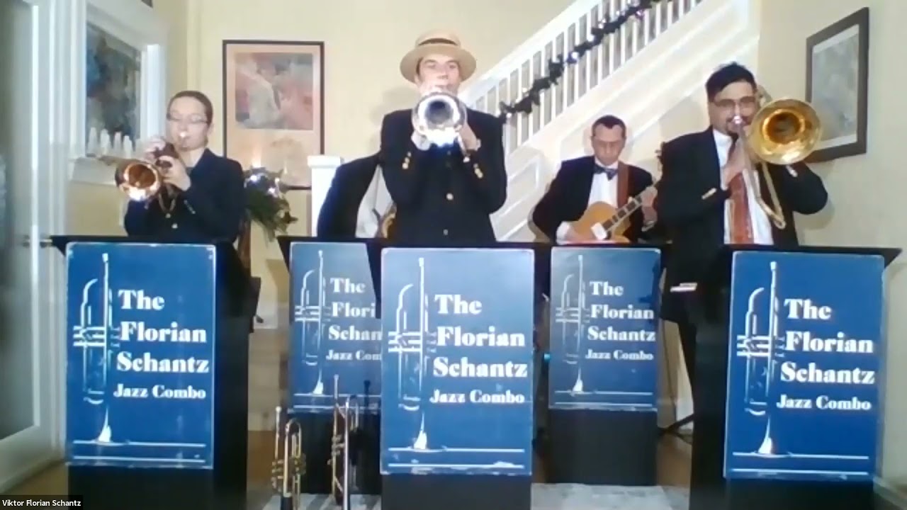 Color photo of the VFS jazz band standing behind labelled podiums playing their instruments