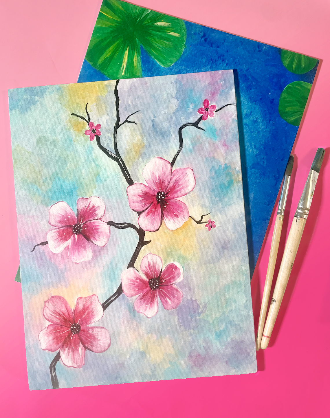 painting of four cherry blossoms on a branch with a multicolor watercolor effect background