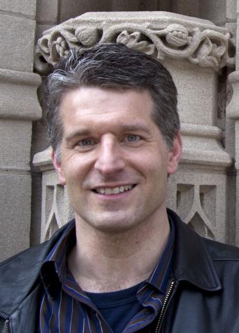 Speaker standing in front of a statue 