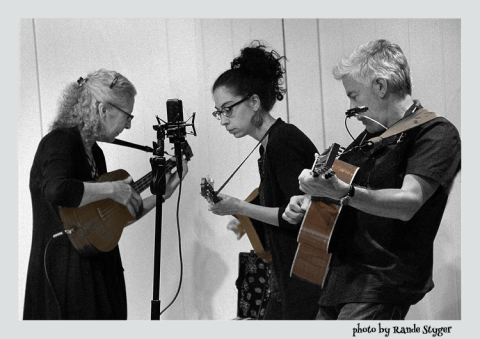 Black and white photo of three musicians with stringed instruments 