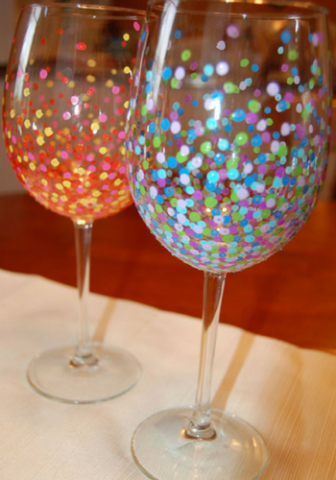 color photo of two wine glasses each with colorful dots on the base