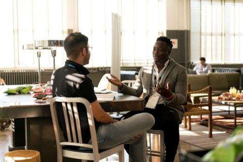 two people in chairs talking animatedly to each other