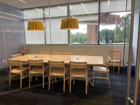 conference room with table, two yellow lamps and windows 