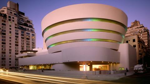 Color photo of the Guggenheim Museum with the sun setting in the background