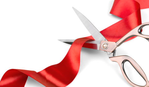 giant scissors cut a red ribbon 