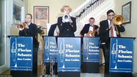 The band performs in front of a white staircase