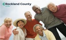 group of seniors standing under the logo for the Rockland County government