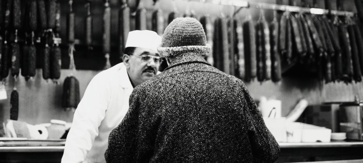 black and white photo of a woman at a deli counter