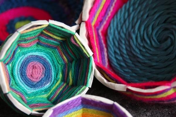 three bowls of varying sizes and color made from yarn and paper plates