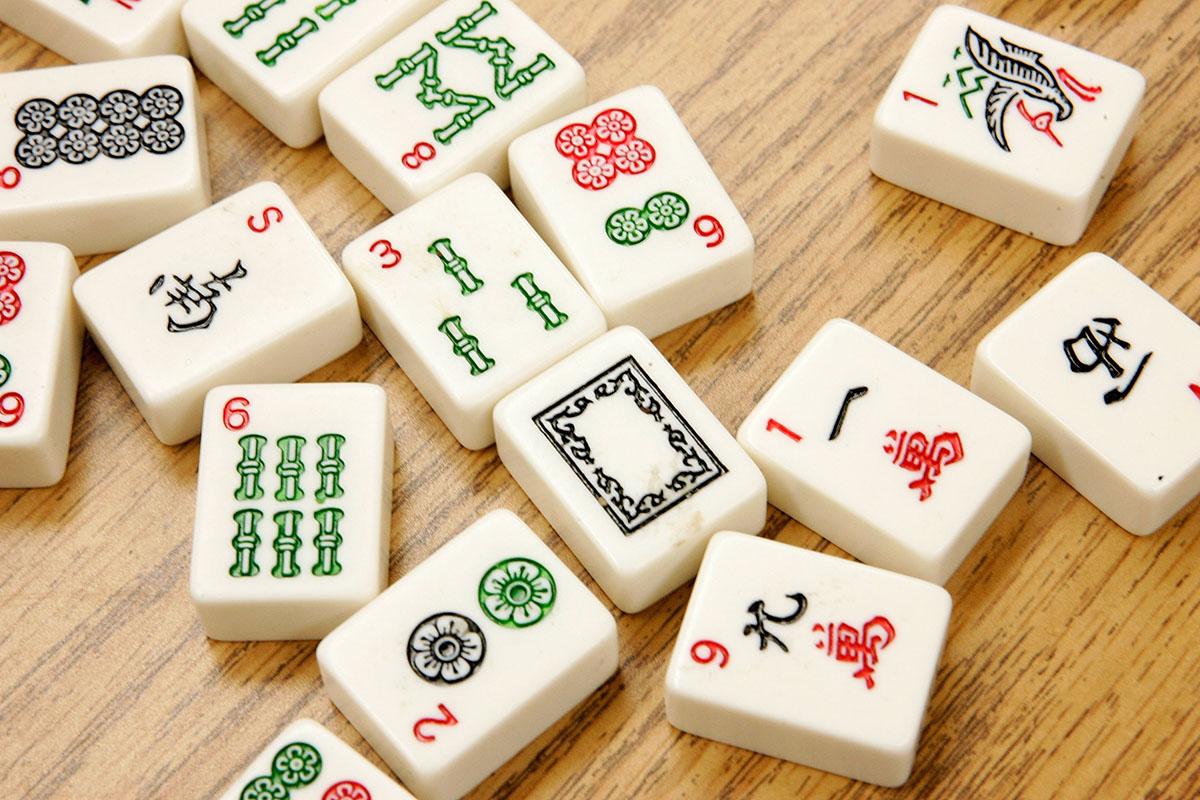 color photo of a scattering of mah jongg tiles over a wooden surface 