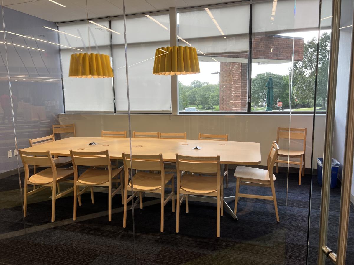 conference room with table, two yellow lamps and windows 