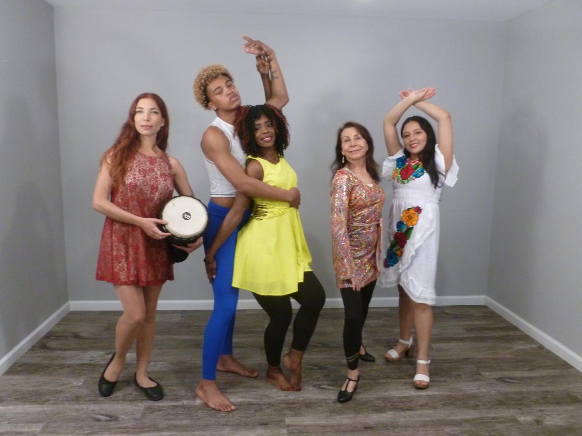 group of performers in a room with grey walls 