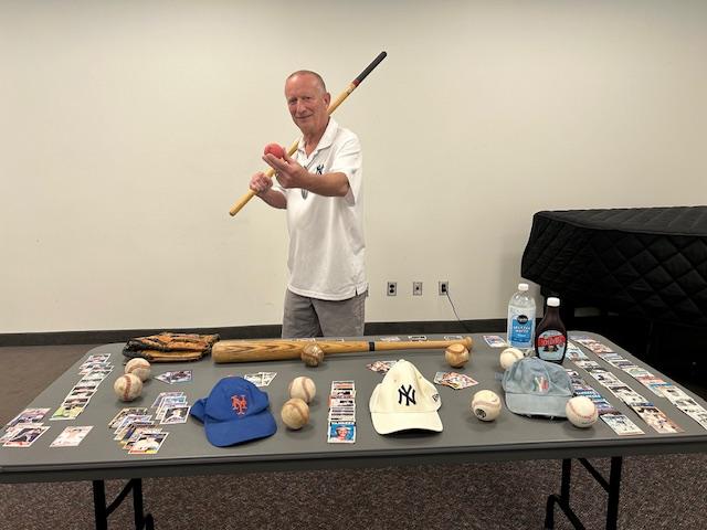 Herb Fisher with a table of baseball memorabilia 