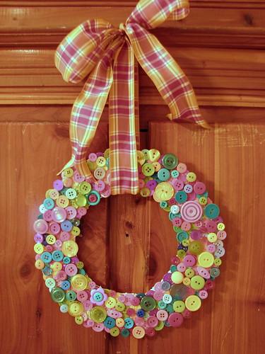 color photo of a button wreath hanging by a ribbon