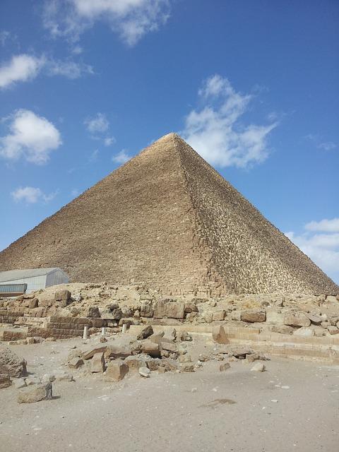 color photograph of a pyramid against a blue sky with few clouds 