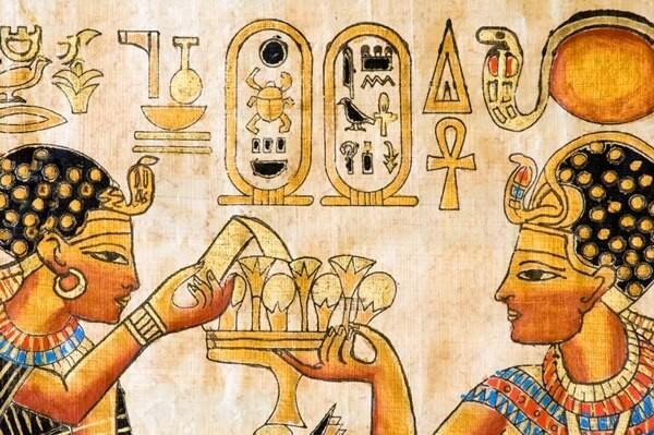 Hieroglyphs and a depiction of two people in profile, one holding a tray of glasses and the other taking one of the glasses 