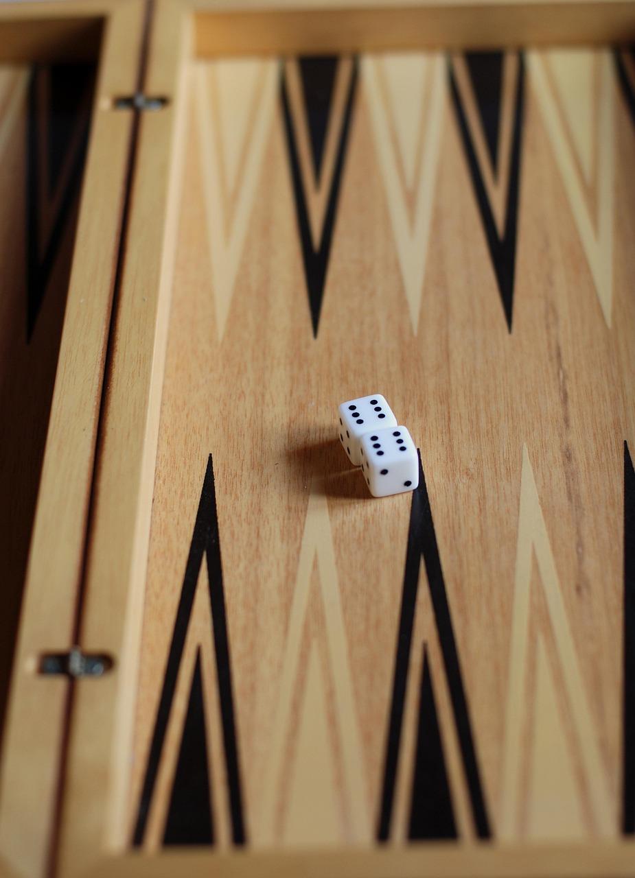 a close up picture of a backgammon board with a single die resting in the middle 